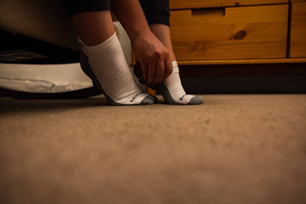 Compression Socks Being Put On At Edge Of Bed